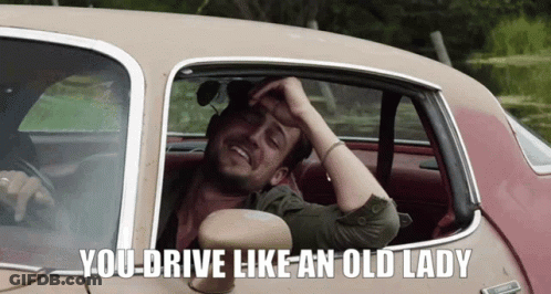 A Man Sitting In A Car With The Words " You Drive Like An Old Lady " Above Him GIF
