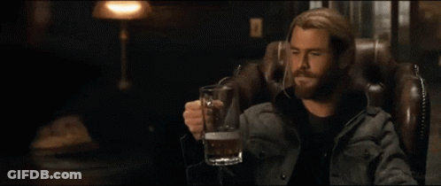 A Man Sitting In A Chair Holding A Beer Mug GIF