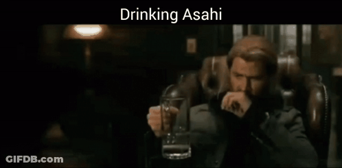 A Man Sitting In A Chair Holding A Glass Of Beer With The Words Drinking Asahi Above Him GIF