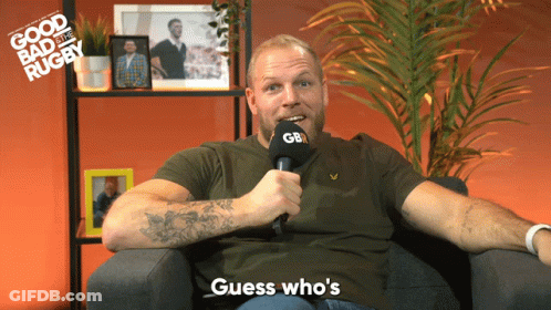 A Man Sitting In A Chair Holding A Microphone That Says Gb GIF