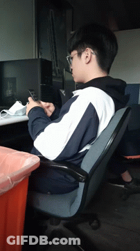 A Man Sitting In A Chair Looking At A Phone GIF