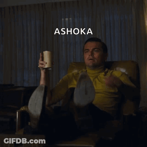 A Man Sitting In A Chair Pointing At Something With The Word Ashoka Written Above Him GIF