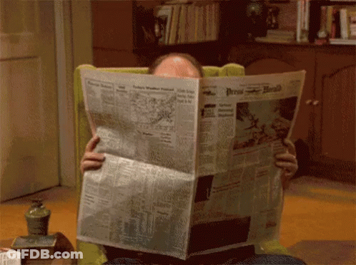 A Man Sitting In A Chair Reading The Press Herald GIF