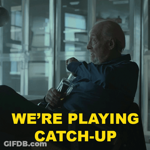 A Man Sitting In A Chair With A Bottle Of Beer And The Words We 'Re Playing Catch-Up Above Him GIF