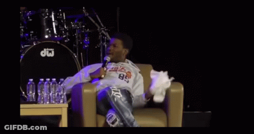 A Man Sitting In A Chair With A Microphone In Front Of A Drum That Says Dw On It GIF