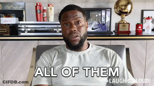 A Man Sitting In A Chair With The Words " All Of Them " On His Shirt GIF