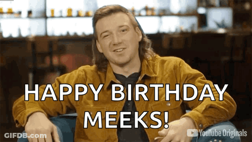 A Man Sitting In A Chair With The Words Happy Birthday Meeks On The Screen GIF