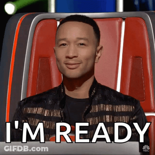 A Man Sitting In A Chair With The Words " I 'M Ready " On The Screen Behind Him GIF