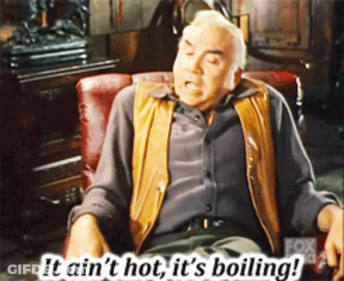 A Man Sitting In A Chair With The Words " It Ain 'T Hot It 'S Boiling " Above Him GIF