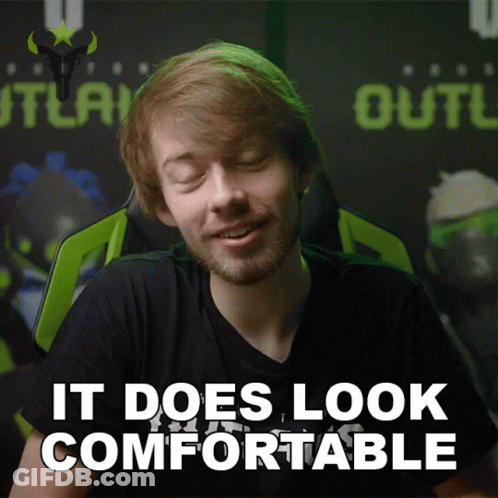 A Man Sitting In A Chair With The Words It Does Look Comfortable Behind Him GIF