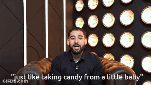 A Man Sitting In A Chair With The Words " Just Like Taking Candy From A Little Baby " On The Bottom GIF