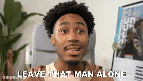 A Man Sitting In A Chair With The Words Leave That Man Alone Above Him GIF