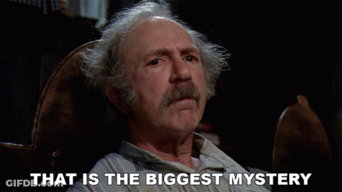 A Man Sitting In A Chair With The Words That Is The Biggest Mystery Above Him GIF
