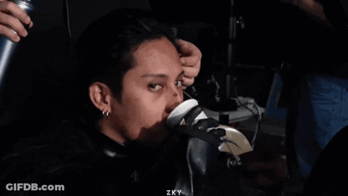 A Man Sitting In A Chair With Zky Written On The Bottom Right GIF