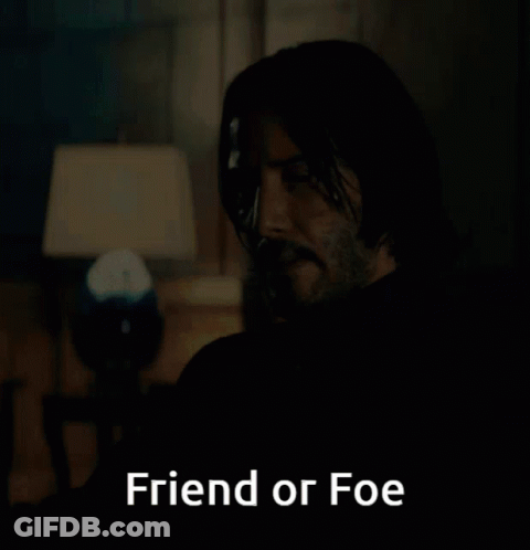 A Man Sitting In A Dark Room With The Words Friend Or Foe Above Him GIF