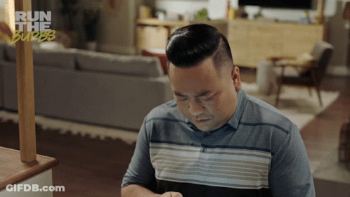 A Man Sitting In A Living Room With The Words Run The Burbs Behind Him GIF
