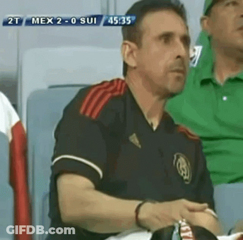 A Man Sitting In A Stadium Watching A Soccer Game Between Mexico And Sui GIF