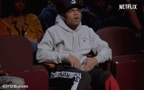 A Man Sitting In A Theatre With A Netflix Logo On The Bottom GIF