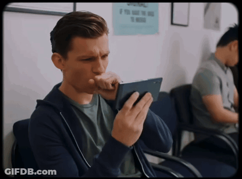 A Man Sitting In A Waiting Room With A Sign On The Wall That Says Please GIF