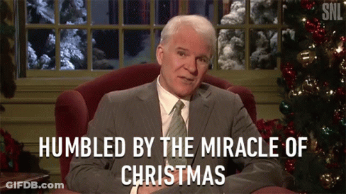 A Man Sitting In Front Of A Christmas Tree With The Words Humbled By The Miracle Of Christmas GIF