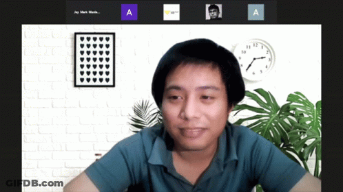 A Man Sitting In Front Of A Clock With The Letters A And A Next To Him GIF