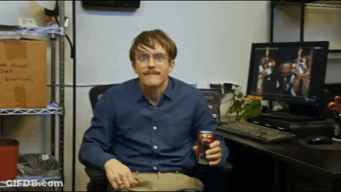 A Man Sitting In Front Of A Computer Holding A Can Of Diet Coke GIF