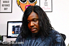 A Man Sitting In Front Of A Computer With A Sign On The Wall That Says Would Beyonce Do ? GIF