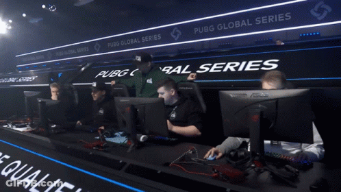 A Man Sitting In Front Of A Computer With A Sign That Says Pubg Global Series GIF