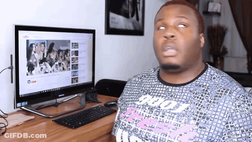 A Man Sitting In Front Of A Computer With A Youtube Channel Open On The Screen GIF