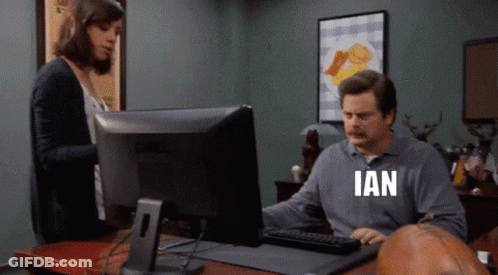A Man Sitting In Front Of A Computer With The Word Ian Written On His Shirt GIF