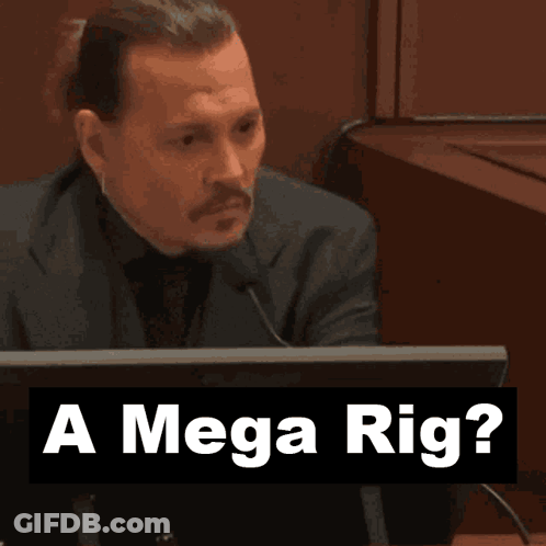 A Man Sitting In Front Of A Computer With The Words " A Mega Rig " Behind Him GIF