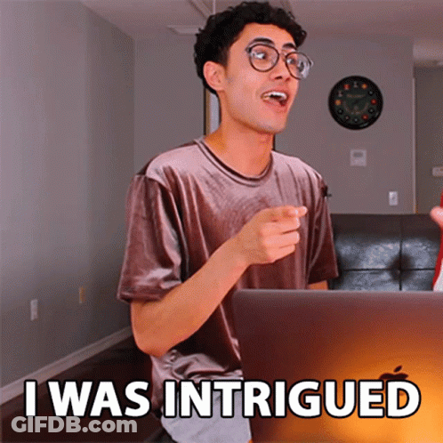 A Man Sitting In Front Of A Laptop With The Words I Was Intrigued On The Screen GIF
