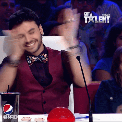 A Man Sitting In Front Of A Microphone With A Cup Of Pepsi In Front Of Him GIF