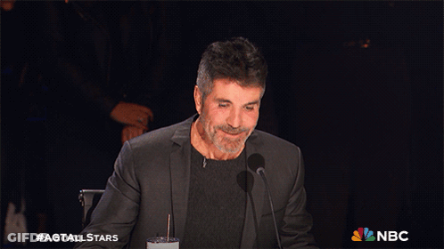 A Man Sitting In Front Of A Microphone With The Nbc Logo On The Bottom Right GIF