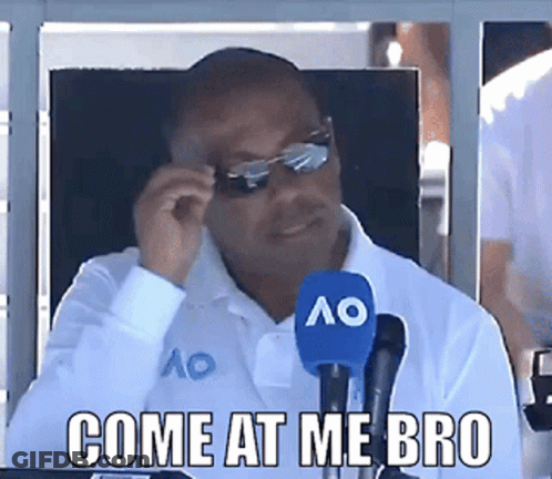 A Man Sitting In Front Of A Microphone With The Words Come At Me Bro GIF