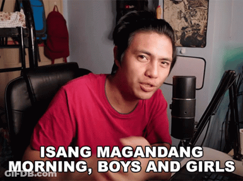 A Man Sitting In Front Of A Microphone With The Words Isang Magandang Morning Boys And Girls Above Him GIF