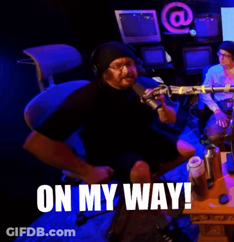 A Man Sitting In Front Of A Microphone With The Words On My Way Written On The Bottom GIF