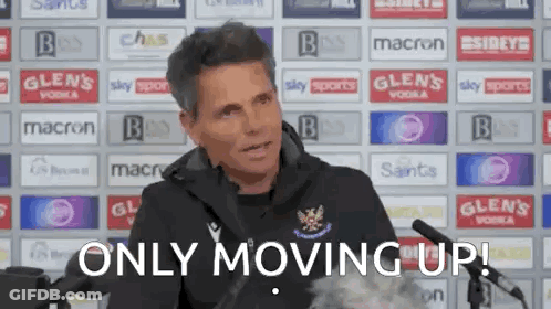 A Man Sitting In Front Of A Microphone With The Words `` Only Moving Up '' Written Below Him . GIF