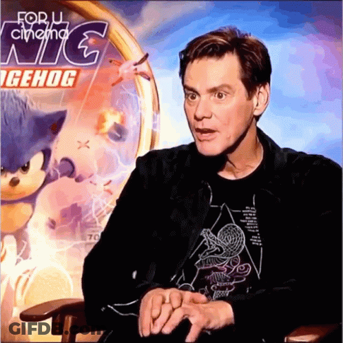 A Man Sitting In Front Of A Sign That Says For U Cinema Nc GIF