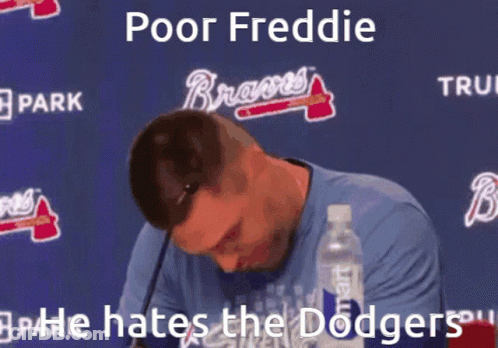A Man Sitting In Front Of A Sign That Says " Poor Freddie " On It GIF