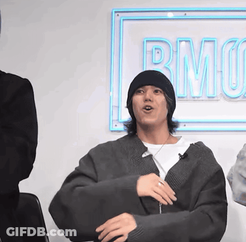 A Man Sitting In Front Of A Sign That Says Rmo On It GIF