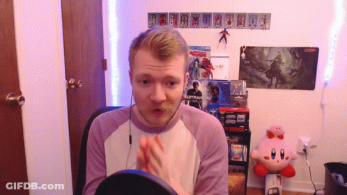 A Man Sitting In Front Of A Sign That Says ' Spiderman 2 ' On It GIF