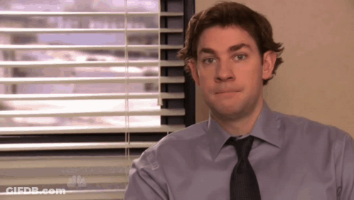 A Man Sitting In Front Of A Window With Blinds And A Nbc Logo GIF