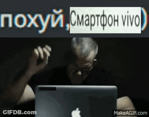 A Man Sitting In Front Of An Apple Laptop With A Makeagif.com Watermark On The Bottom GIF