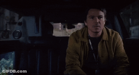 A Man Sitting In The Back Seat Of A Car With A Lanyard Around His Neck That Says ' Fortune ' On It GIF