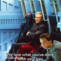 A Man Sitting Next To A Woman With The Words We Love What You 'Ve Done With Your Hair Above Them GIF