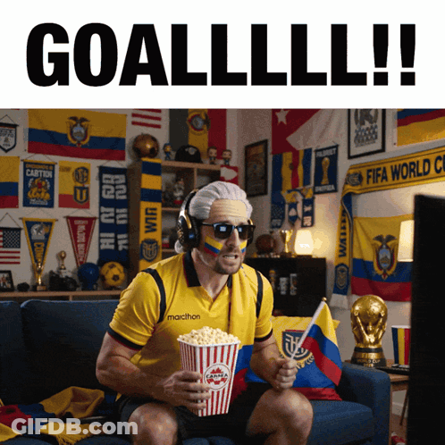 A Man Sitting On A Couch Eating Popcorn And Wearing A Marathon Jersey GIF