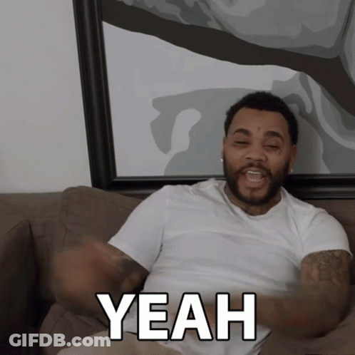 A Man Sitting On A Couch Says Yeah With His Arms Outstretched GIF