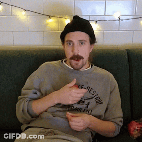 A Man Sitting On A Couch Wearing A Shirt That Says " Destroy " On It GIF