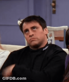 A Man Sitting On A Couch With A Black Shirt On That Says Fox GIF
